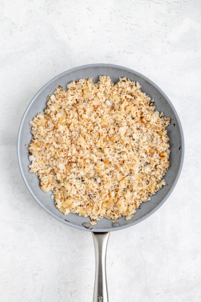 Skillet with fried rice on a light surface.