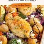 Sheet pan with baked Greek chicken, potatoes, red onions, zucchini, and cheese crumbles for an easy one-pan meal.