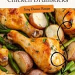 Oven-baked chicken drumsticks, roasted potatoes, and asparagus on a pan with herbs; easy dinner recipe text overlay.