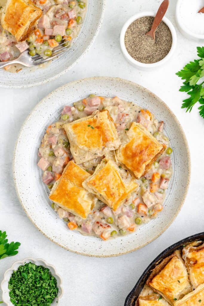 Creamy Ham and Vegetable Pot Pie served in a bowl, topped with square puff pastry crusts.